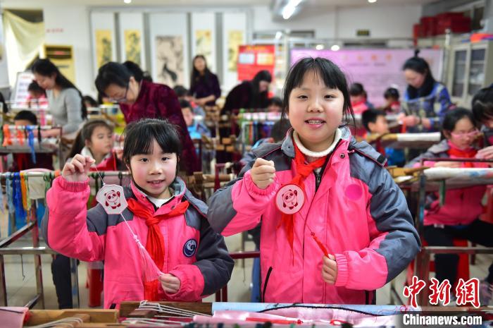 图为小学生展示绣制好的2022年北京冬奥会吉祥物“冰墩墩”形象。　喻云亮 摄