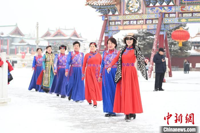 2月13日，老年人在呼和浩特市大召广场拍照“打卡”。　刘文华 摄