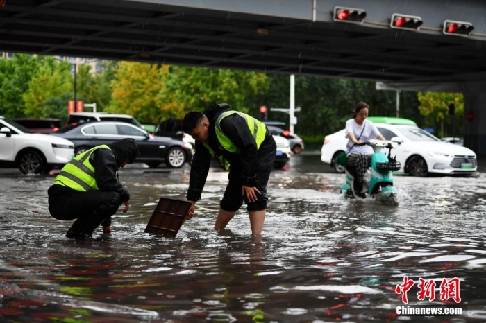 7月30日，河北省持续发布暴雨红色预警信号。受今年第5号台风“杜苏芮”残余环流影响，7月28日以来，地处华北地区的河北省大部出现降雨。30日17时，该省气象台发布当日第三次暴雨红色预警信号。石家庄市城区不少区域积水严重，城管、环卫、园林、市政等部门紧急出动，联合疏堵保畅，筑牢防汛安全屏障。图为石家庄裕华区城管局防汛队员对沿街收水井进行杂物清理，以保证排水畅通。翟羽佳 摄