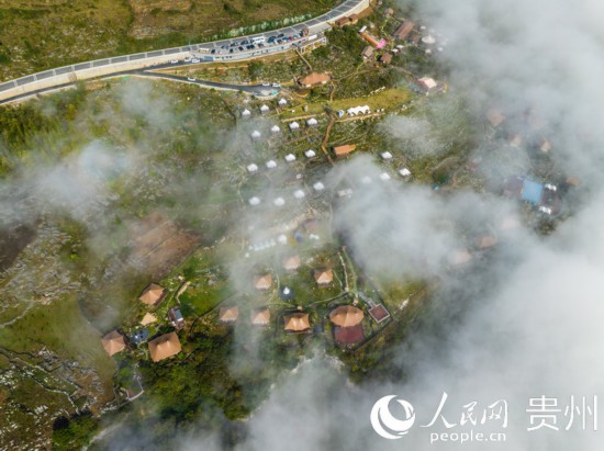 航拍掩映在晨间薄雾中的“花都里·化屋野奢度假营地“。人民网 阳茜摄