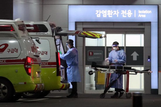 2022年3月22日，在韩国首尔，急救医疗中心医务人员对救护车和担架进行消毒。新华社/纽西斯通讯社