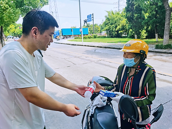 何超为过路的老人送上矿泉水和冷饮。人民网记者 王继亮摄