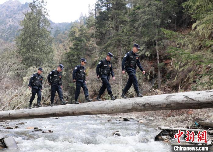 山南边境管理支队玉麦边境派出所民警边境巡逻途中走过河道上“独木桥”。　郑琦山 摄