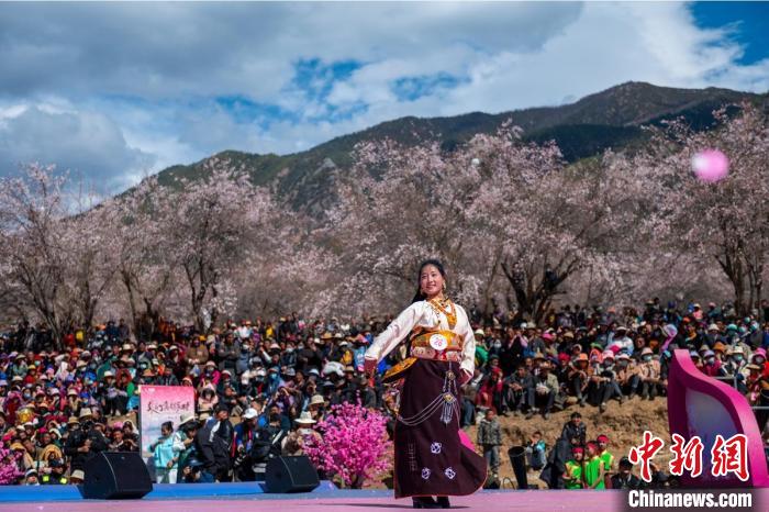 桃花林下精彩的“桃花仙子”选拔吸引村民或游客。　刘忠俊 摄