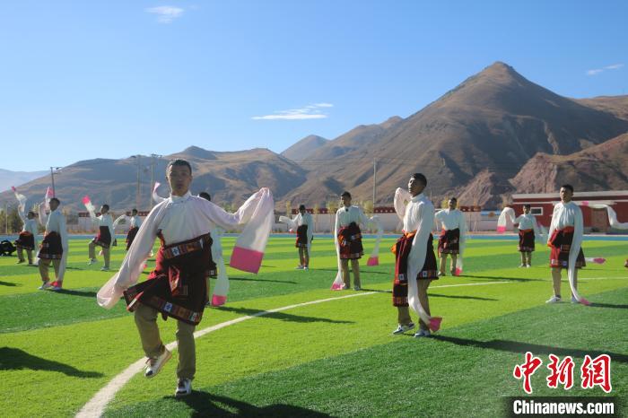 图为青海师范大学附属玉树实验学校学生在绿茵场跳起囊谦古舞—卓根玛。　程雨 摄