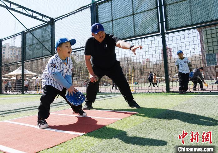 图为来自台湾的棒球教练刘兴鸿(右)指导小棒球手接球技术。　马铭言 摄