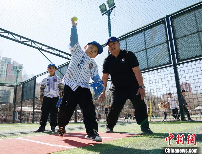 图为来自台湾的棒球教练刘兴鸿(右)指导小棒球手掷球技术。　马铭言 摄