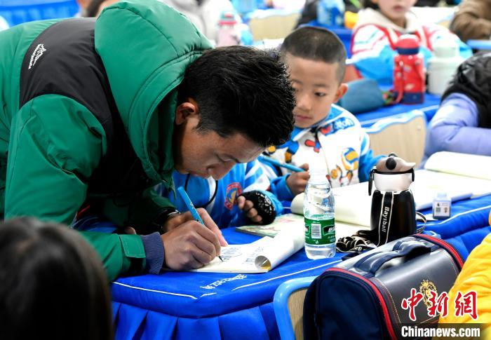 3月14日，西藏拉萨市第一小学藏语文老师拉巴次仁在课堂上手把手教学生藏文书法。　李林 摄