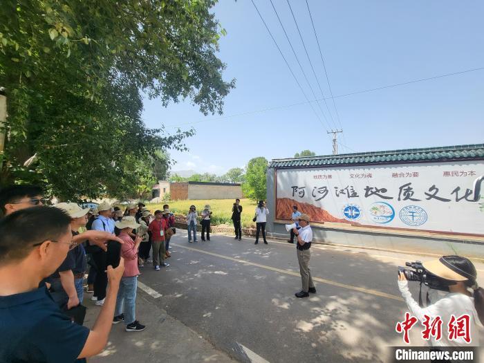 图为中国地质大学(北京)教授张绪教介绍村落情况。　胡友军 摄