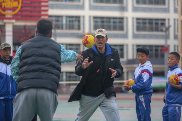 在高原上教孩子们打手球，“慢慢儿来，甭着急！”