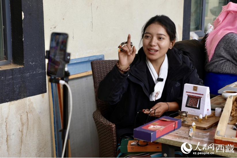 图为高校毕业生返乡就业，在藏香工厂内进行电商直播。人民网记者 次仁罗布摄