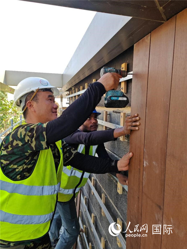 工作人员在安装竹材外墙。人民网记者管克江摄