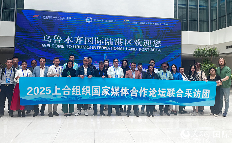 5月26日，外国媒体人在乌鲁木齐国际陆港区合影留念。 人民网记者 翟转丽摄