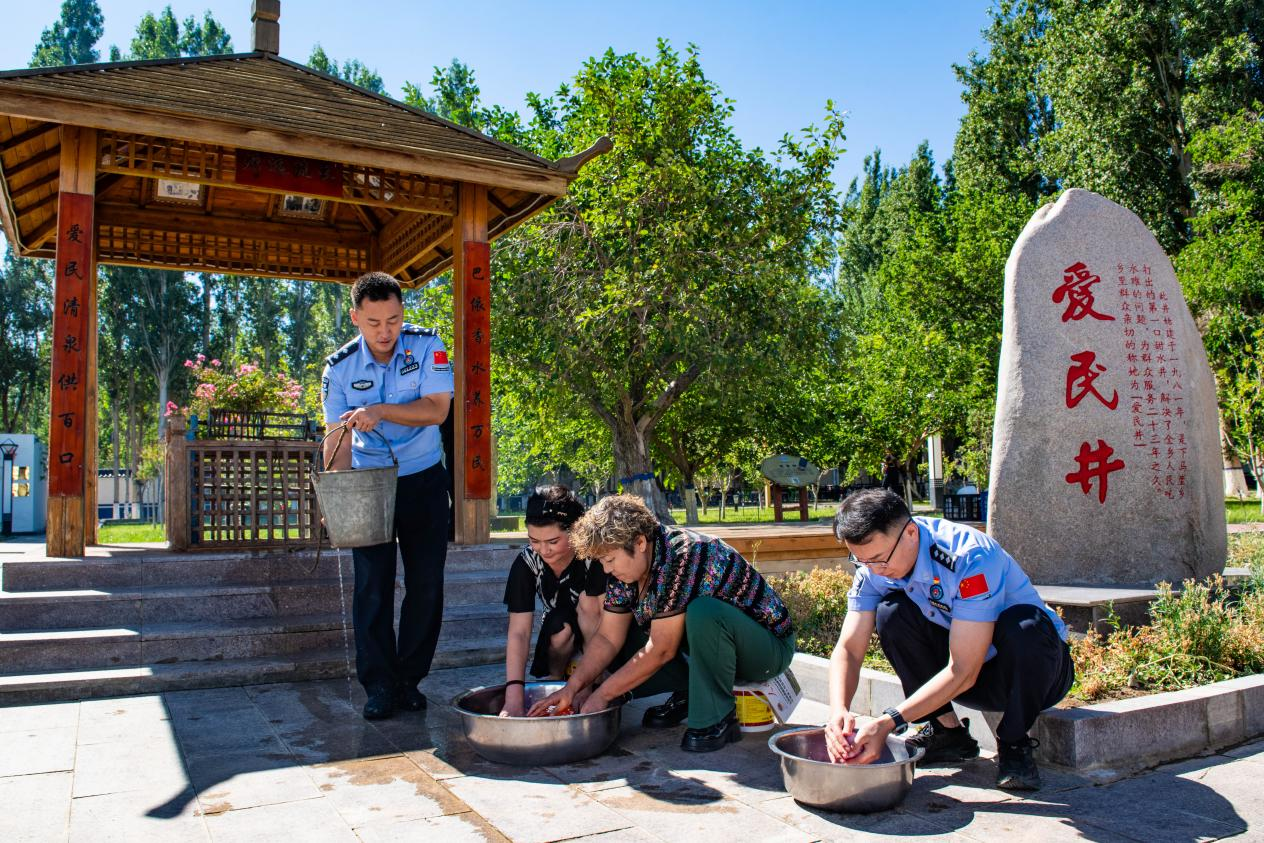 下马崖边境派出所民警与辖区群众在“爱民井”旁，一同打水洗菜、架锅做饭。下马崖边境派出所供图