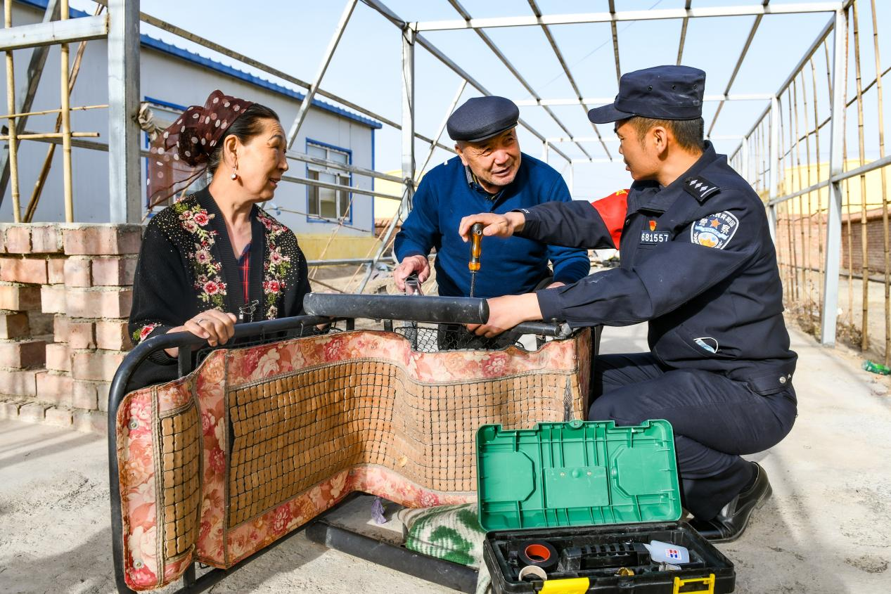 下马崖边境派出所民警何春明在辖区群众家中维修躺椅。下马崖边境派出所供图