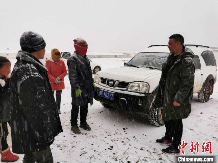 图为扎西闹吾(右一)与当地牧户交谈。邮储银行青海省分行供图