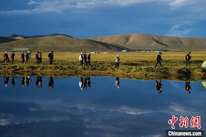 图为国内外摄影师们在查旦湿地中前行。　马铭言 摄