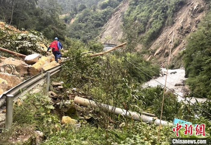 电力抢险人员快速通过危险路段，旁边是受损的电力线路 四川电力供图