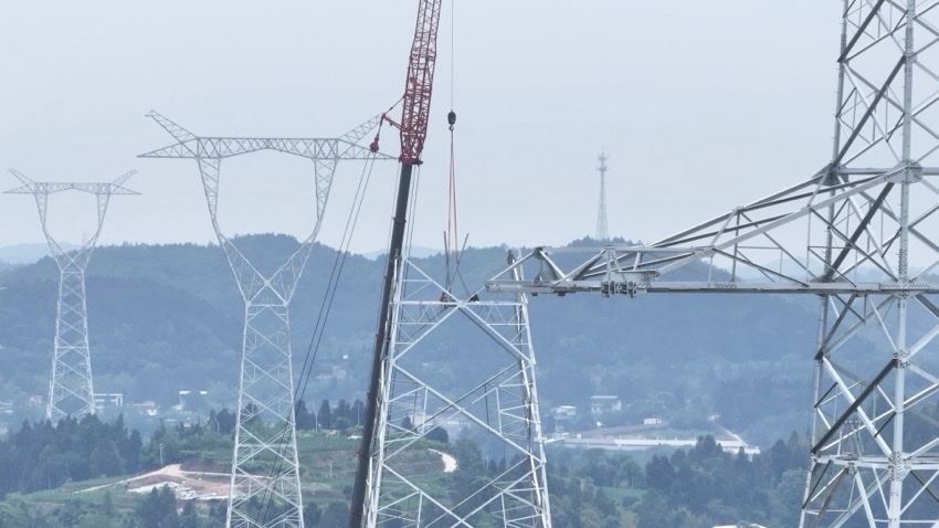 在四川省绵阳市,阿坝—成都东1000千伏特高压交流工程作业人员正在开展吊车组塔。国网四川建设公司供图