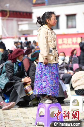 图为观看节目的小女孩。　贡嘎来松 摄