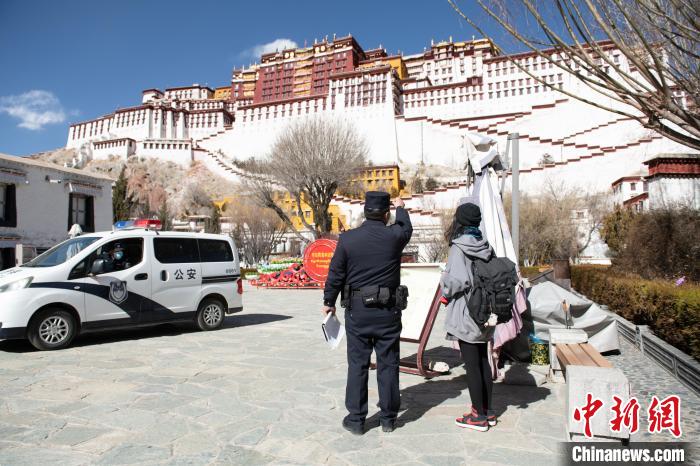 图为1月23日，布达拉宫广场派出所民警正在帮助游客找回丢失的相机。　贡嘎来松 摄