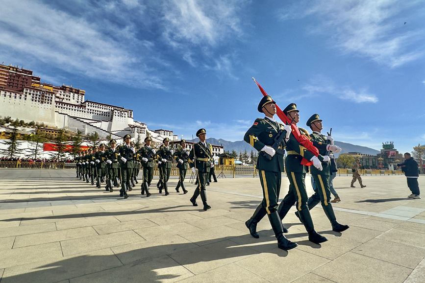 国旗护卫队护送国旗走向升旗台。