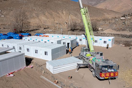2025年1月9日，在定日县长所乡古荣村安置点，救援人员和施工人员合力抓紧搭建移动板房，确保受灾群众温暖过冬。人民网记者 翁奇羽摄
