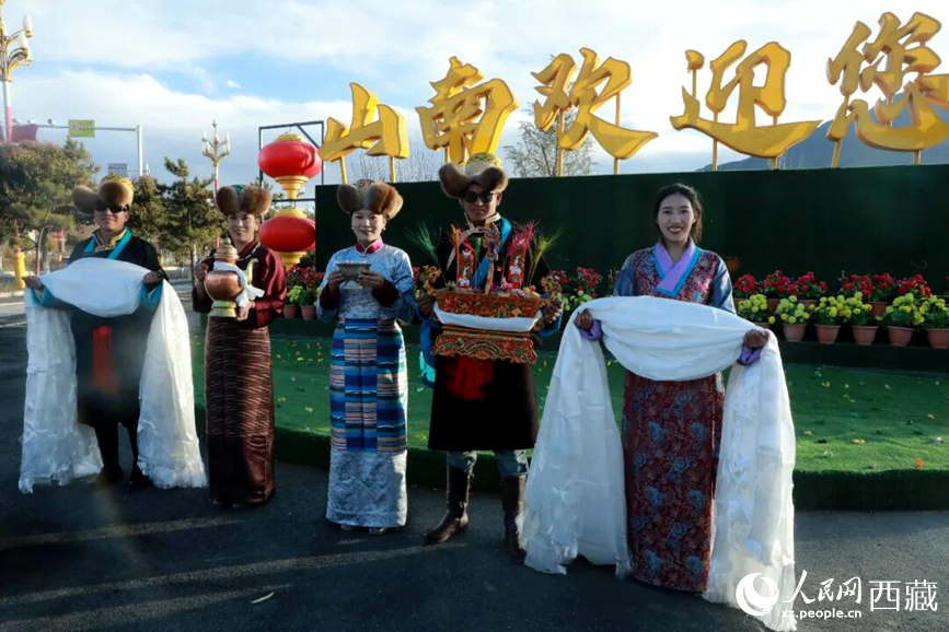 扎西曲登社区的居民在“山南欢迎您”标志前,手持洁白哈达和切玛,列队迎接来自区内外的游客,用最隆重的礼仪开启一场沉浸式藏历新年民俗体验之旅。人民网记者 吴雨仁摄