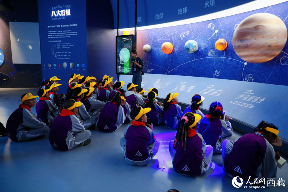 在藏域星球天文体验馆内，科普工作人员正通过巨型环幕为学生们生动讲解天文知识。人民网记者 次仁罗布摄