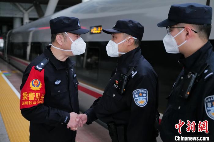 图为深圳铁路公安处乘警支队政委卢光杰(左)在站台叮嘱出乘警长王聪(右二)站好最后一班岗，守护旅客 陈文 摄